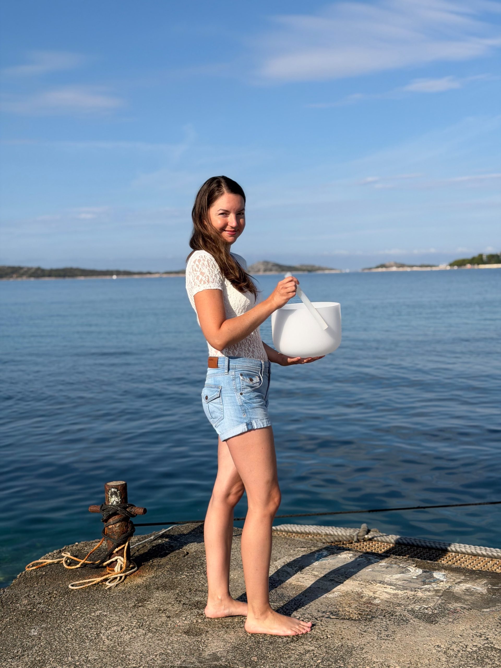Veronika mit einer weißen Klangschale am Meer
